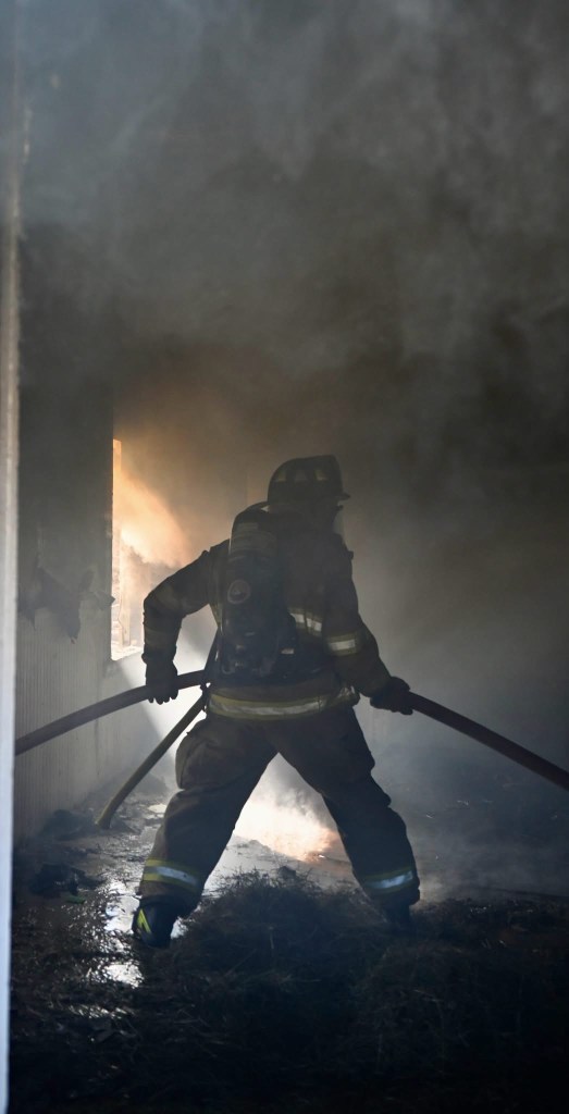 Crews work to advance hoses through smoky conditions.
