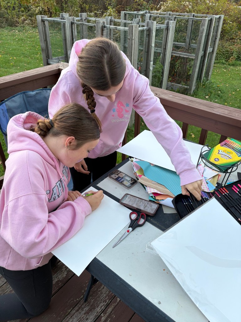 Aubrey Amburgey and Eliana Nicholes work on posters together.