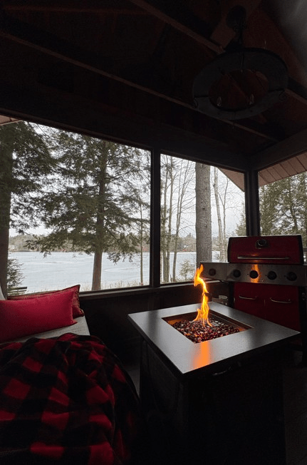 Looking out at a frozen lake from a cozy screened in porch.