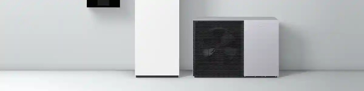 Wärmepumpe mit Innen- und Außengerät vor heller Wand