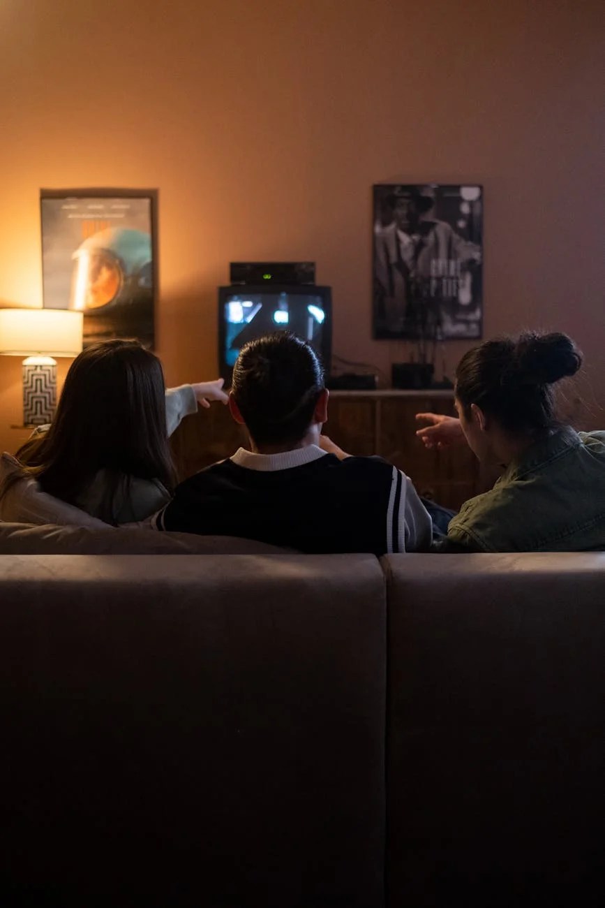 friends watching tv on the couch and pointing something at tv player