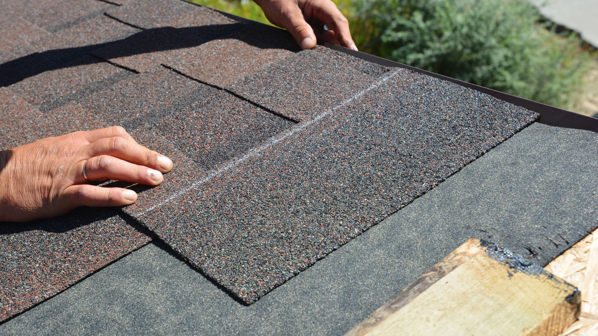 Lemus Construction technician inspecting asphalt shingles on a commercial roof