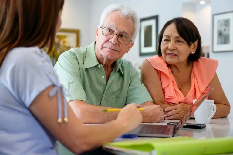 Senior couple meeting with a mortgage advisor to discuss reverse mortgage refinance options