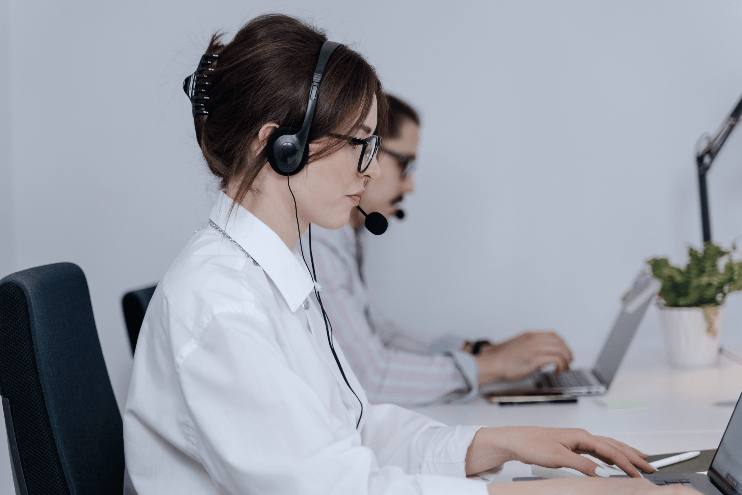 Support specialist wearing a headset while working on a laptop