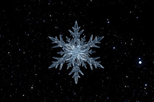 The perfection of an ice crystal against a background of a dark, star-filled sky
