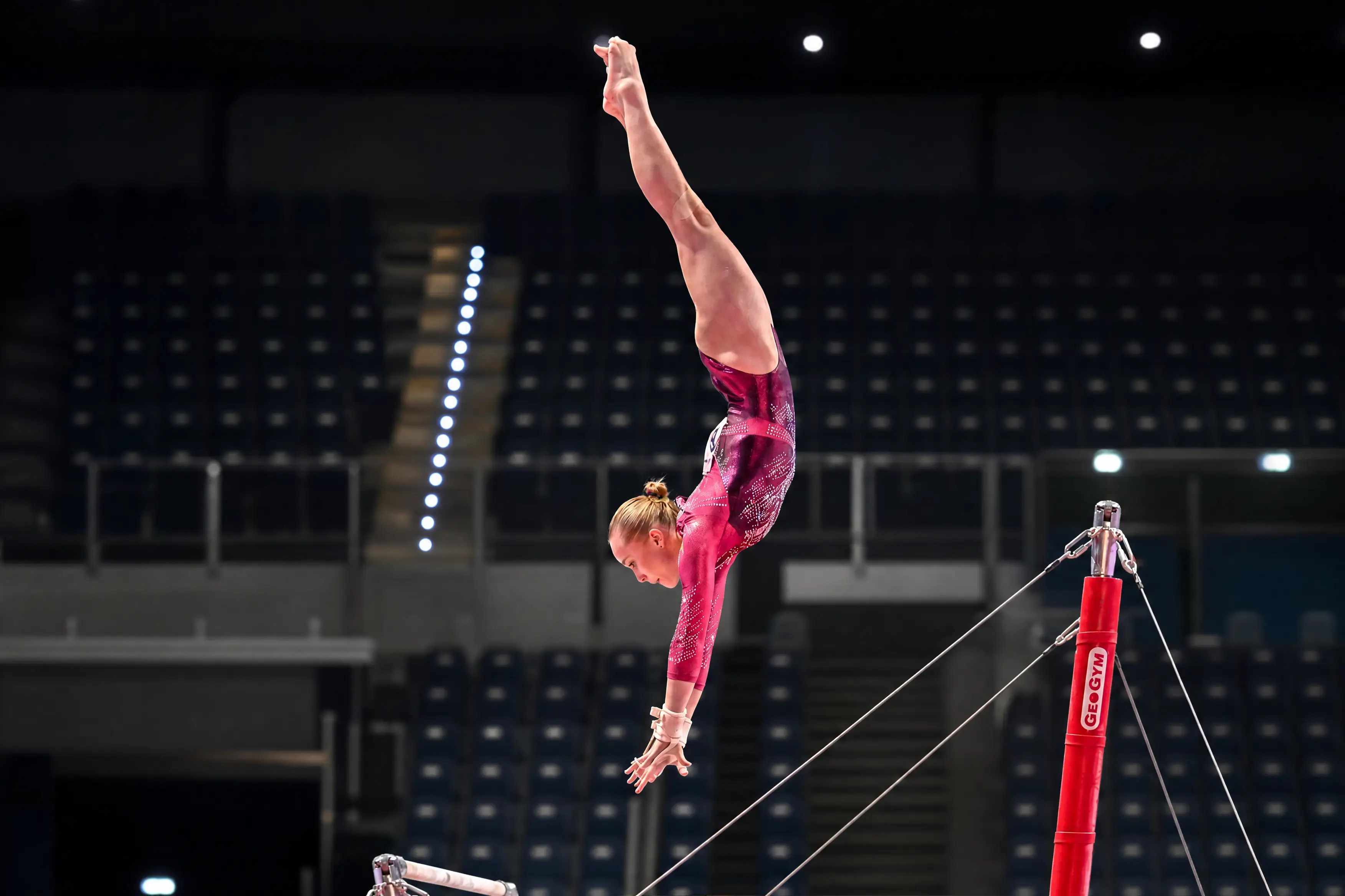 Atleta durante un salto en las barras asimétricas