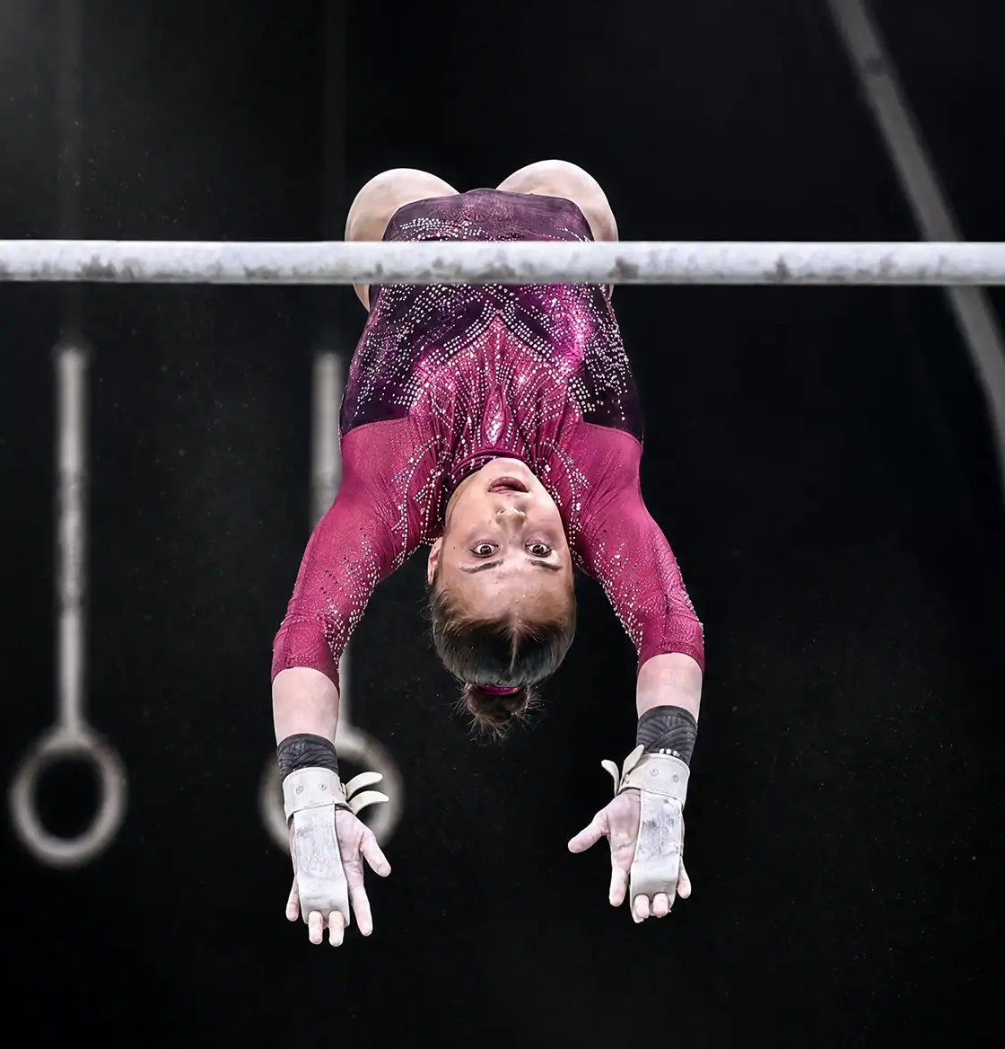 Atleta durante un salto en las barras asimétricas