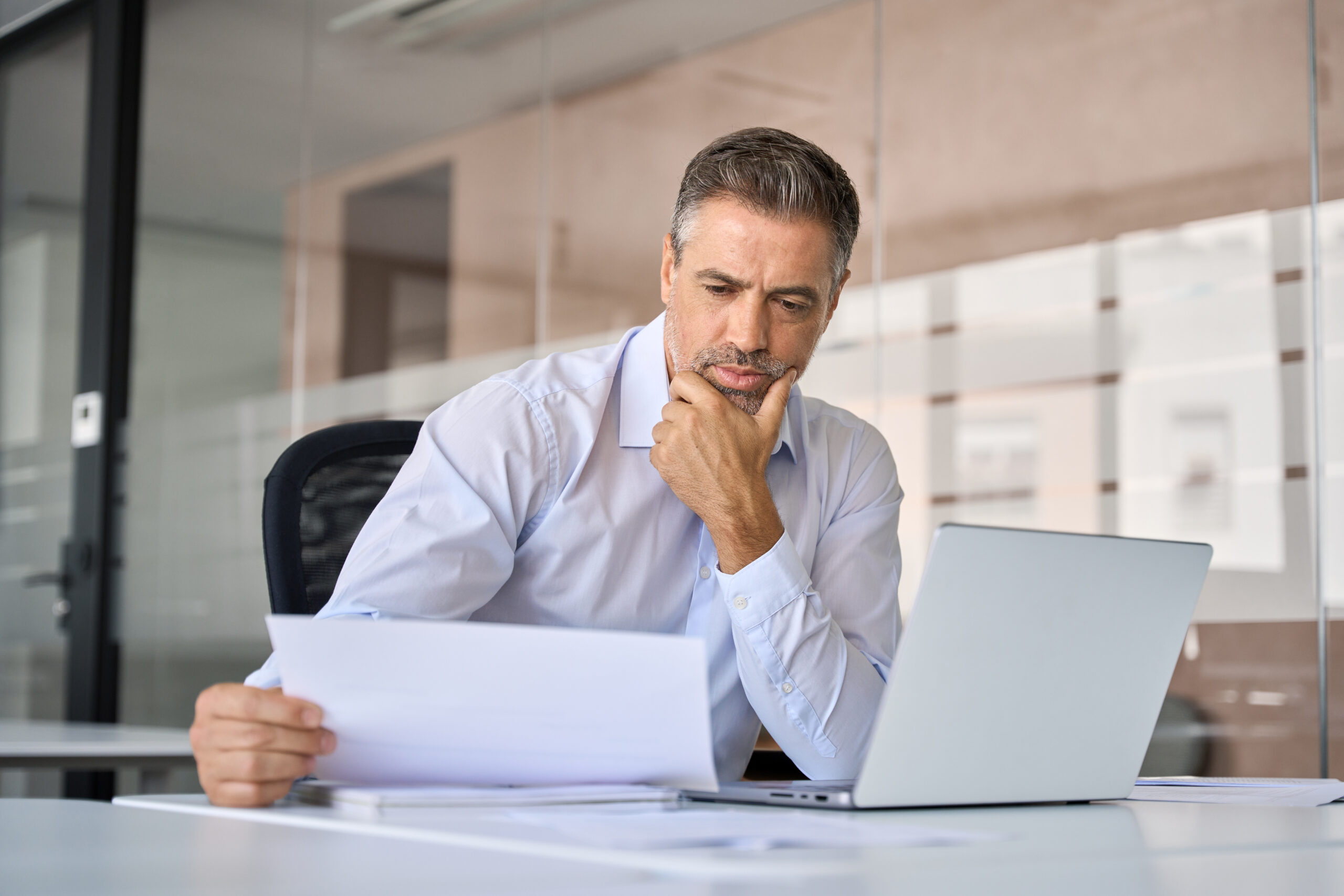 Business owner reviewing paperwork at his desk