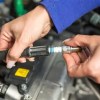 Technician removing a spark plug from Lexus engine