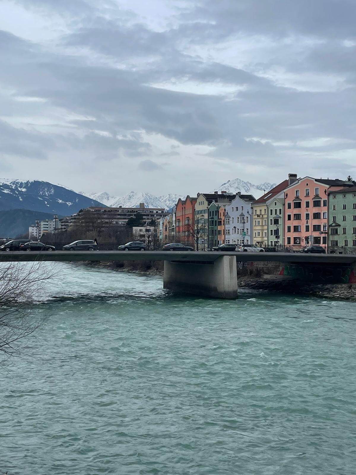 Turquoise River Inn flowing through Innsbruck with mountain views behind the city