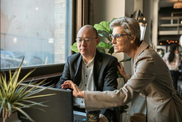 Senior professionals discussing a project at a modern office workspace.