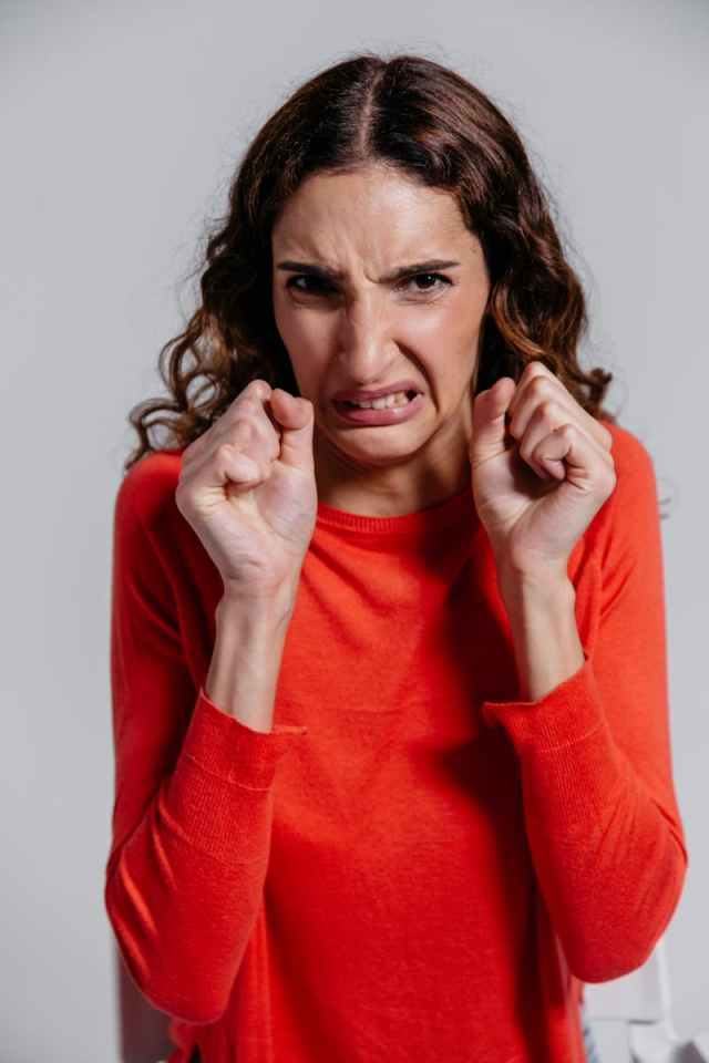 Frustrated woman expressing irritation and emotion indoors.