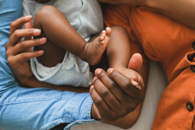 Close-up of a family holding a baby, showcasing love and connection.