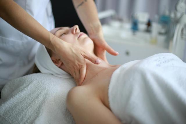 Woman receiving a soothing neck massage at a spa, promoting relaxation and wellness.