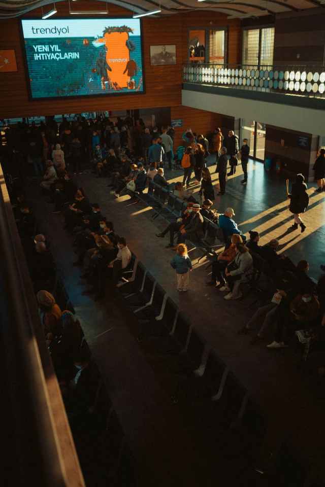 High angle view of people in a transportation terminal waiting room with sun beams streaming in.