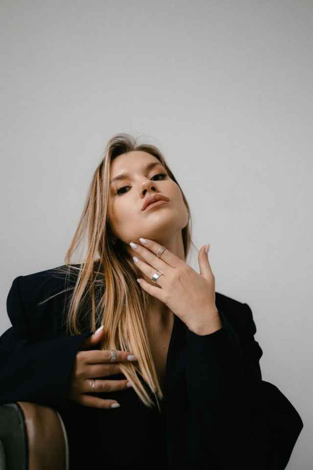 Portrait of a stylish woman with blond hair wearing black attire, showcasing elegance and poise.