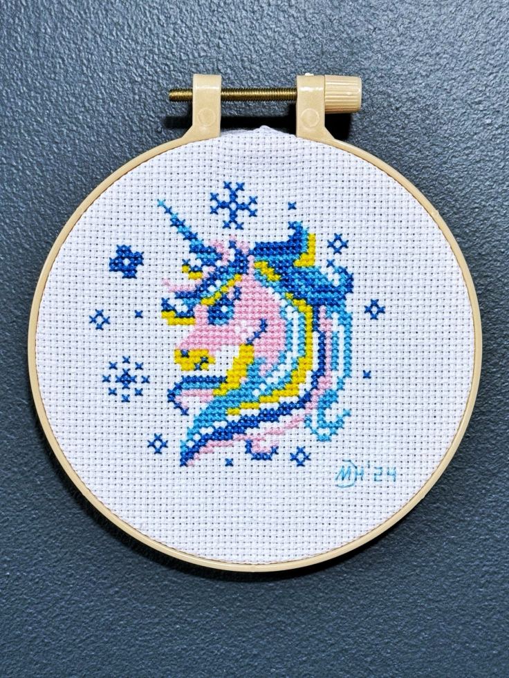 Completed cross-stitch of a unicorn head