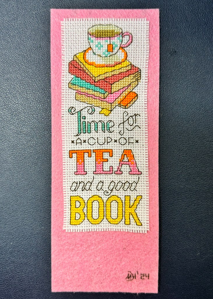 CrossStitched bookmark, has a tea cup on top of some books with the text 'Time for a cup of tea and a good book'