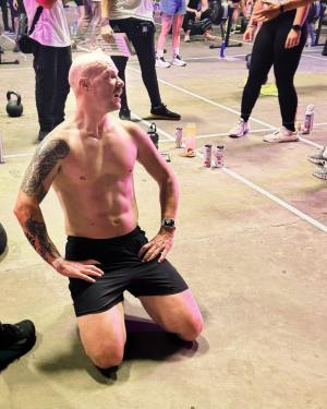 Me kneeling on the floor with my top off after competing in a crossfit competition