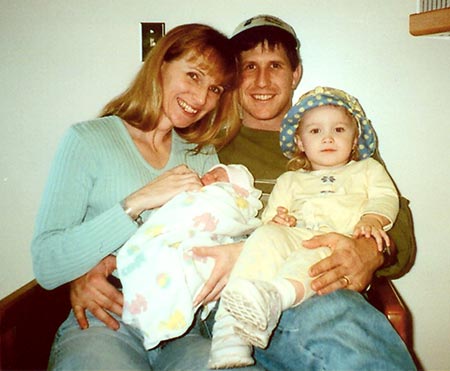 Happy married couple posing with child and their newly adopted infant after waiting for adoption