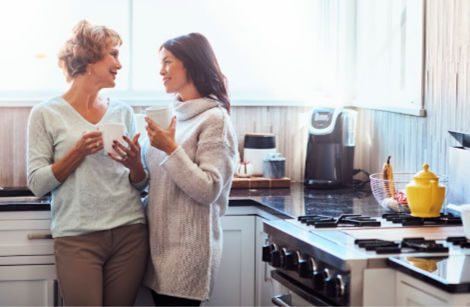 Woman and her mother chatting in the kitchen