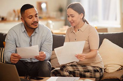 Young couple working on their finances in living room
