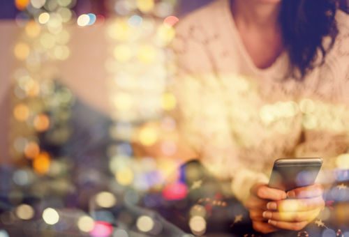 woman looking at her cell phone at night, trying to commit birth mother scams