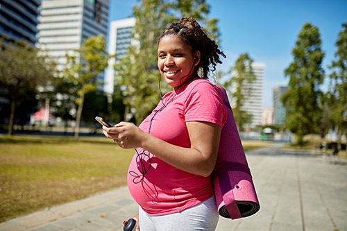 Pregnant Hispanic woman in a park ready to do exercises to get ready for labor