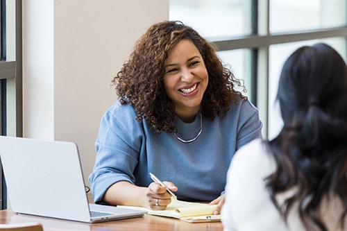 HR professional talks to an employee about employer provided adoption benefits in her office