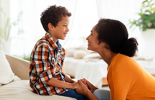 Adoptive mother explaining adoption to her biological child at home