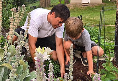 Evan helping his son tend to the family garden