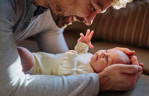 Adoptive father enjoys cuddling his son while on paternity leave