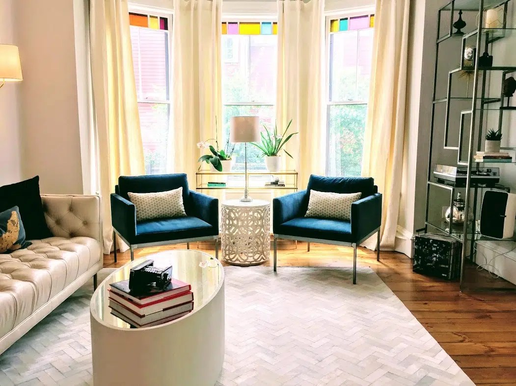 Living room with teal blue chairs, hyde hair rug, cream leather sofa