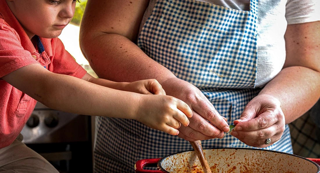 Boy helping Italian grandmother with cooking
