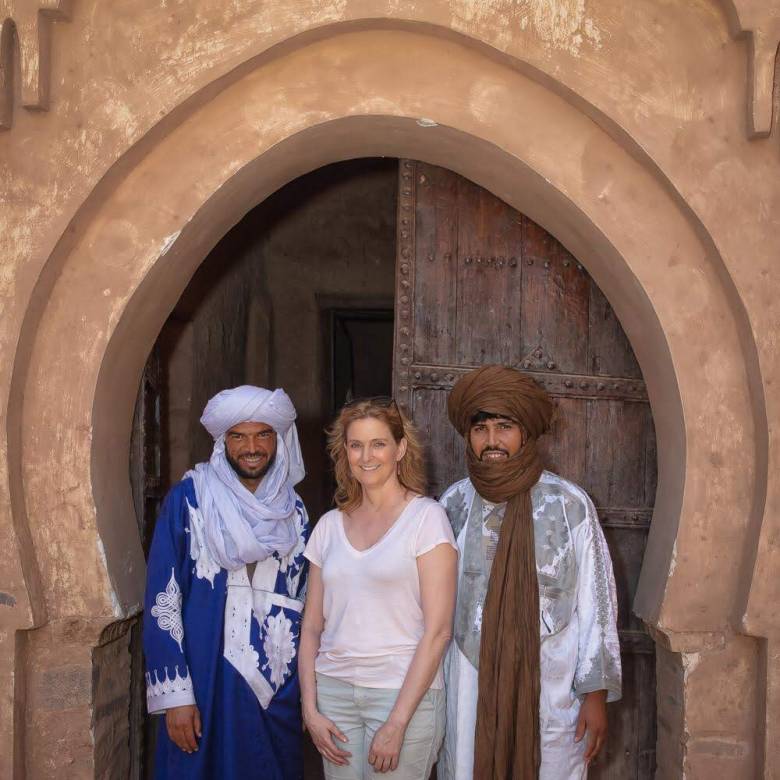 Nancy is pictured beside two Moroccan men, dressed in traditional Moroccan desert clothing, Provided by | Nancy Lee