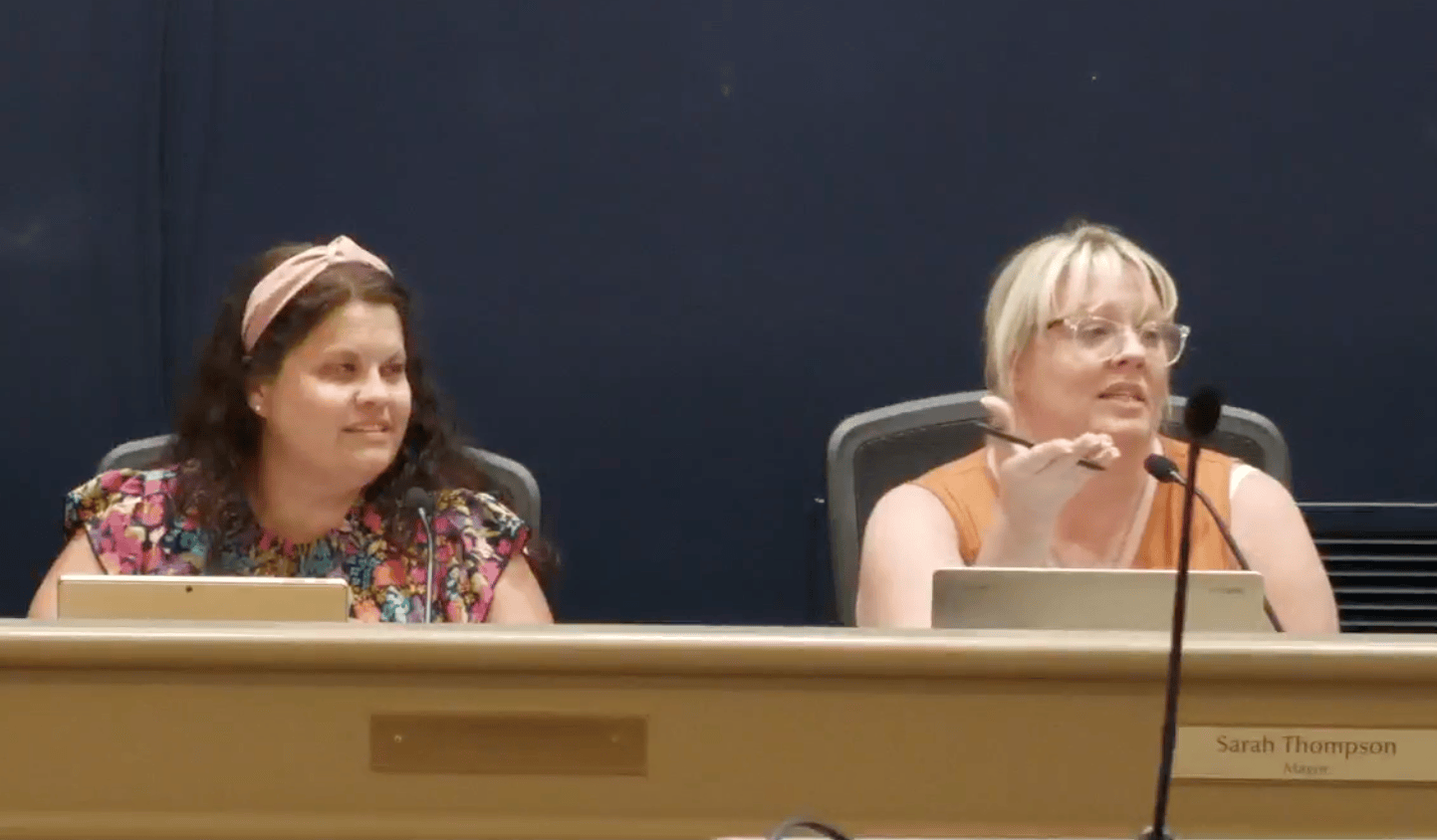 Two women at a podium.