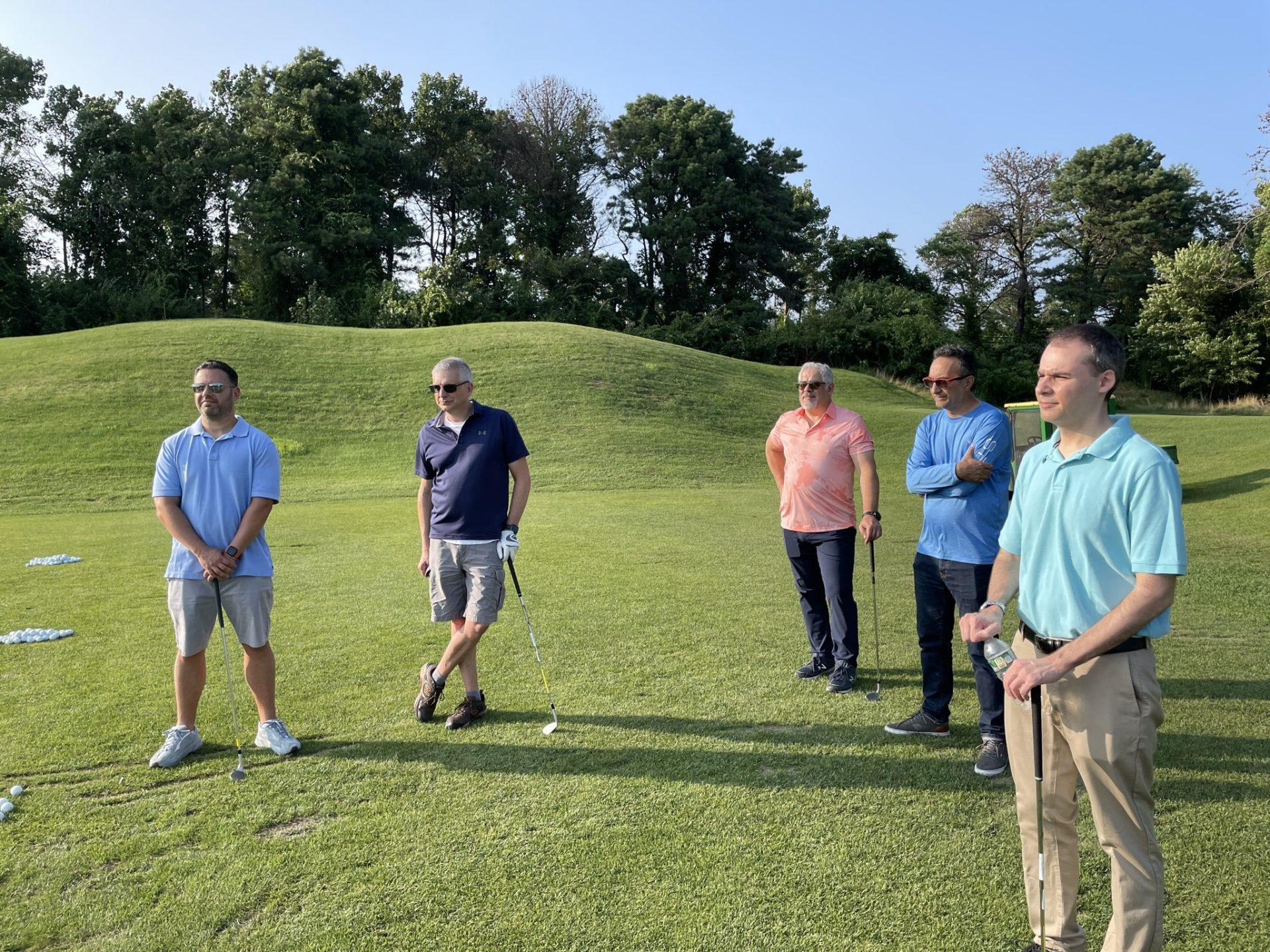 Photo of five men waiting to golf