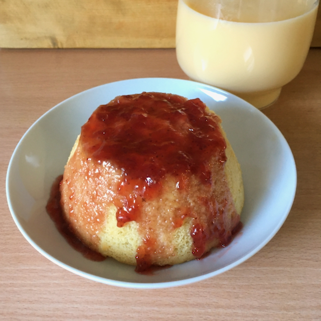 Steamed pudding with strawberry jam and custard in a jug