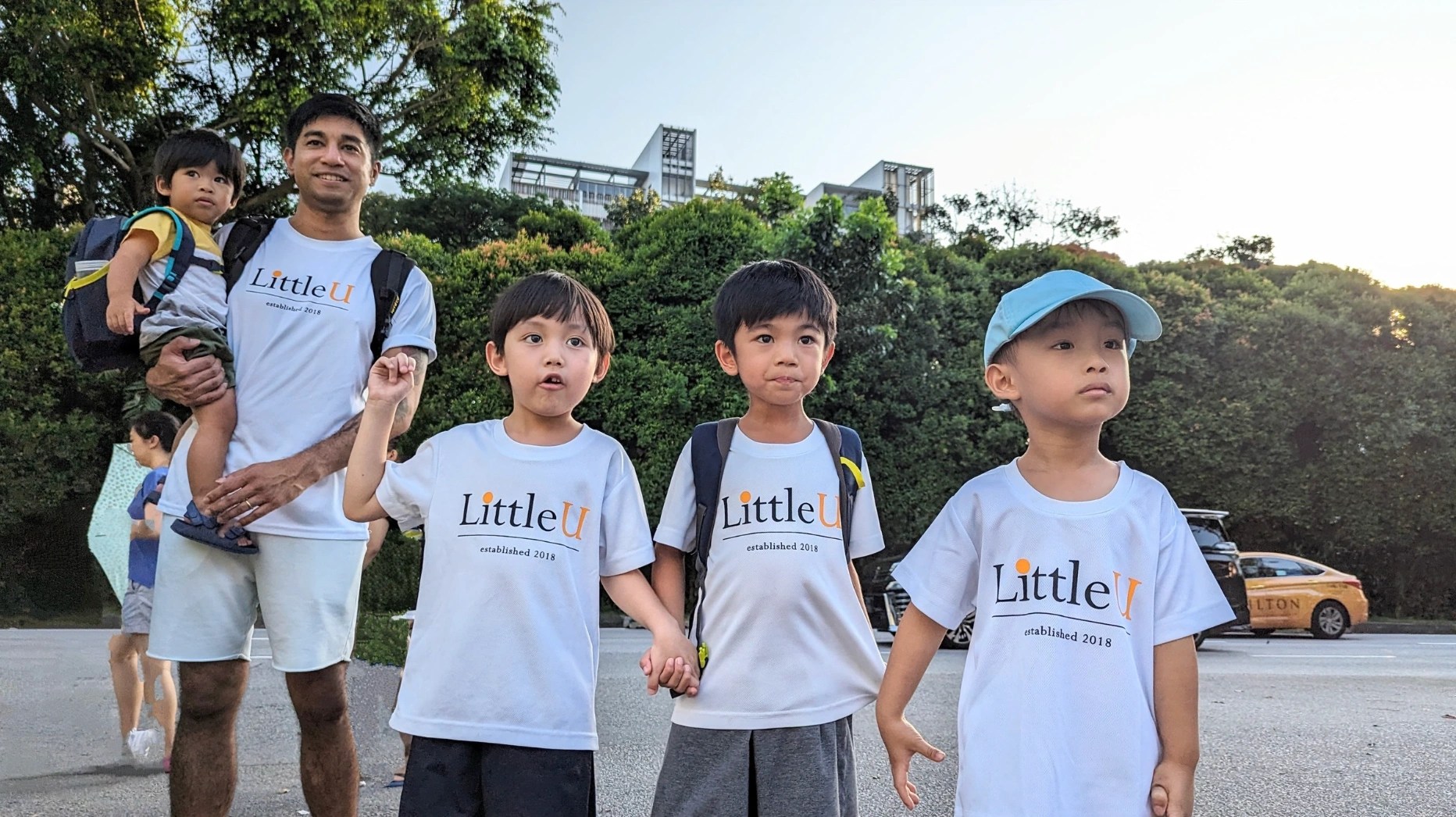 Children wearing Little U tees, looking out into the distance