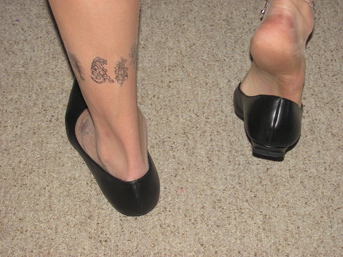 Well worn pointy black leather kitten heels, nylons, tatto…