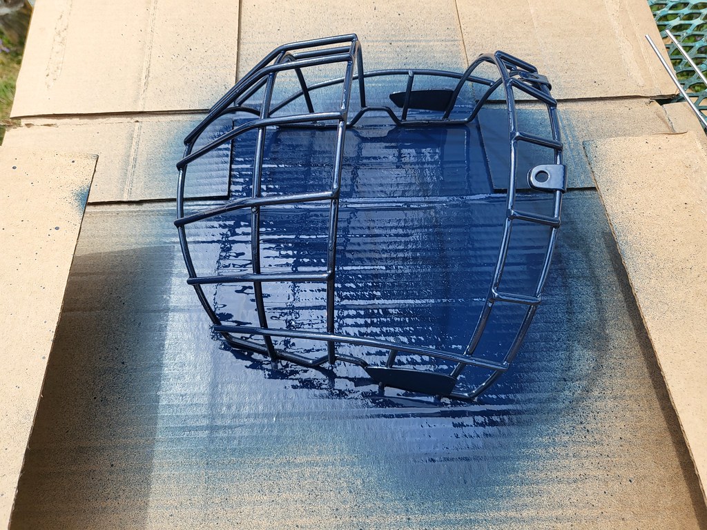 Blue spraypaint on a broomball cage facemask