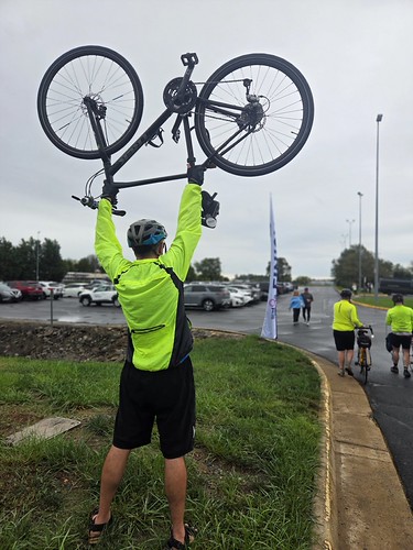 William F. Yurasko lifts his bike aloft after completing 2026 Tour de VRE