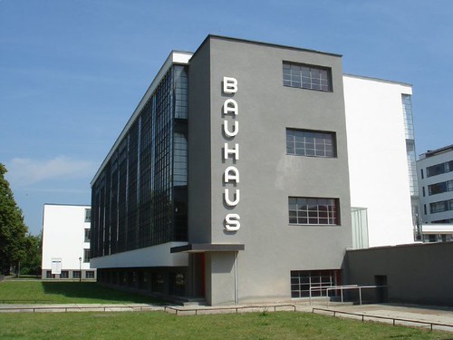 Exterior view of a Bauhaus campus building with flat roofs and ribbon windows in bright daylight.