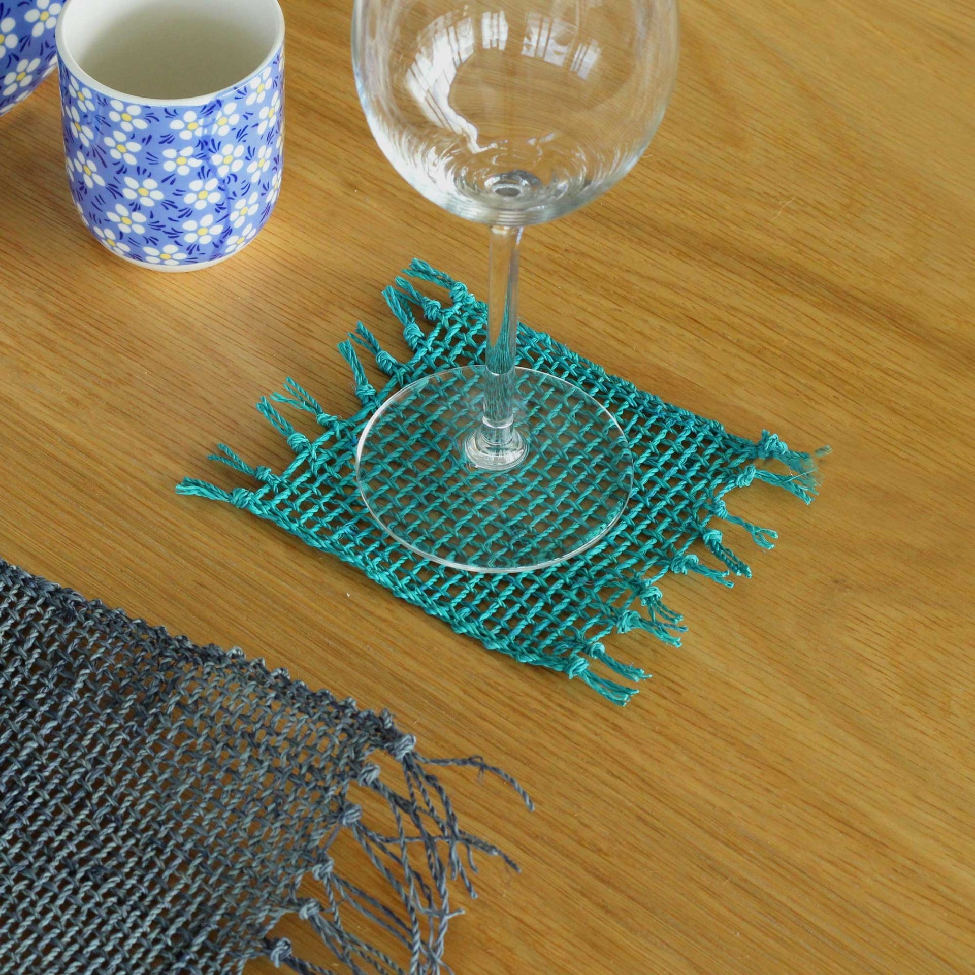 Turquoise seagrass coaster under a wine glass, eco-friendly table decor