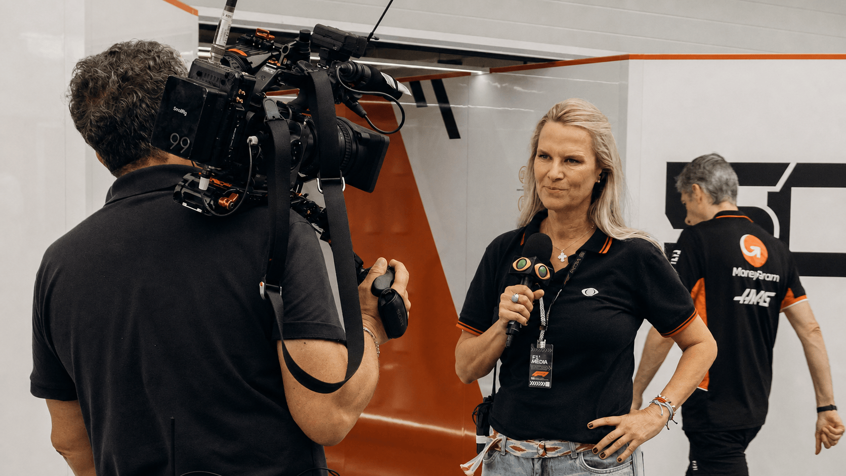 Une journaliste sportive s’exprime face à une caméra dans un espace média automobile