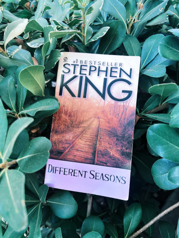 The Book Different Seasons by Stephen King amongst plants