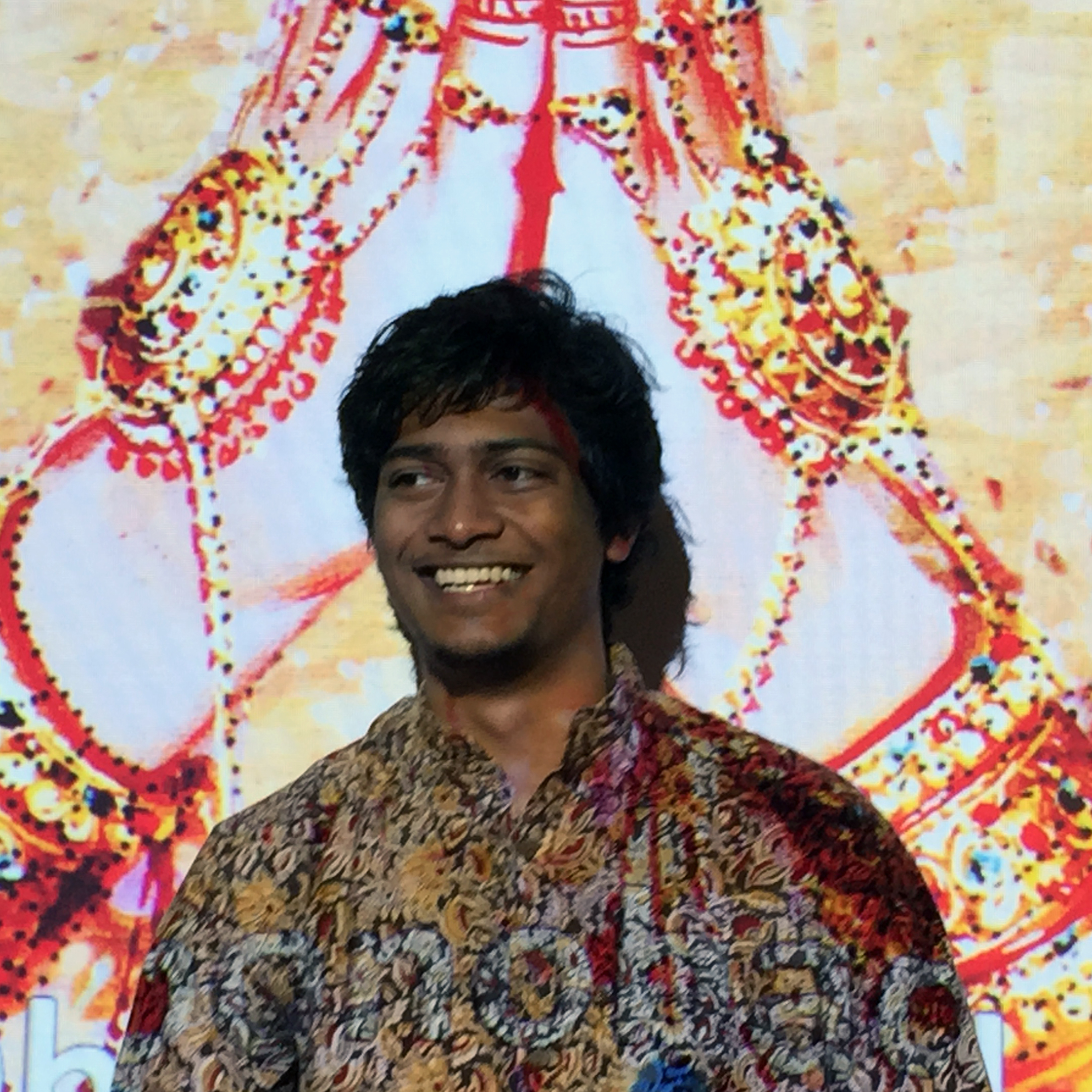 Tito smiling at the end of his presentation as he stood in front of a slide saying "Thank you" in Bengali.