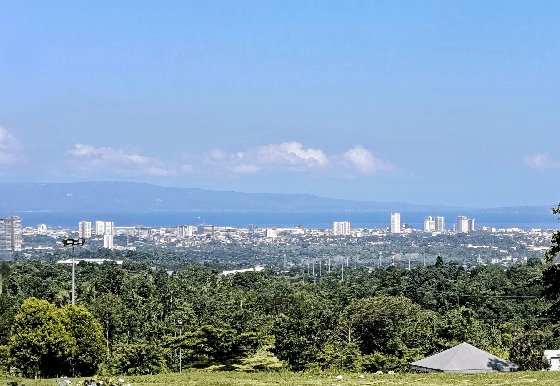 Davao City skyline with lush greenery foreground