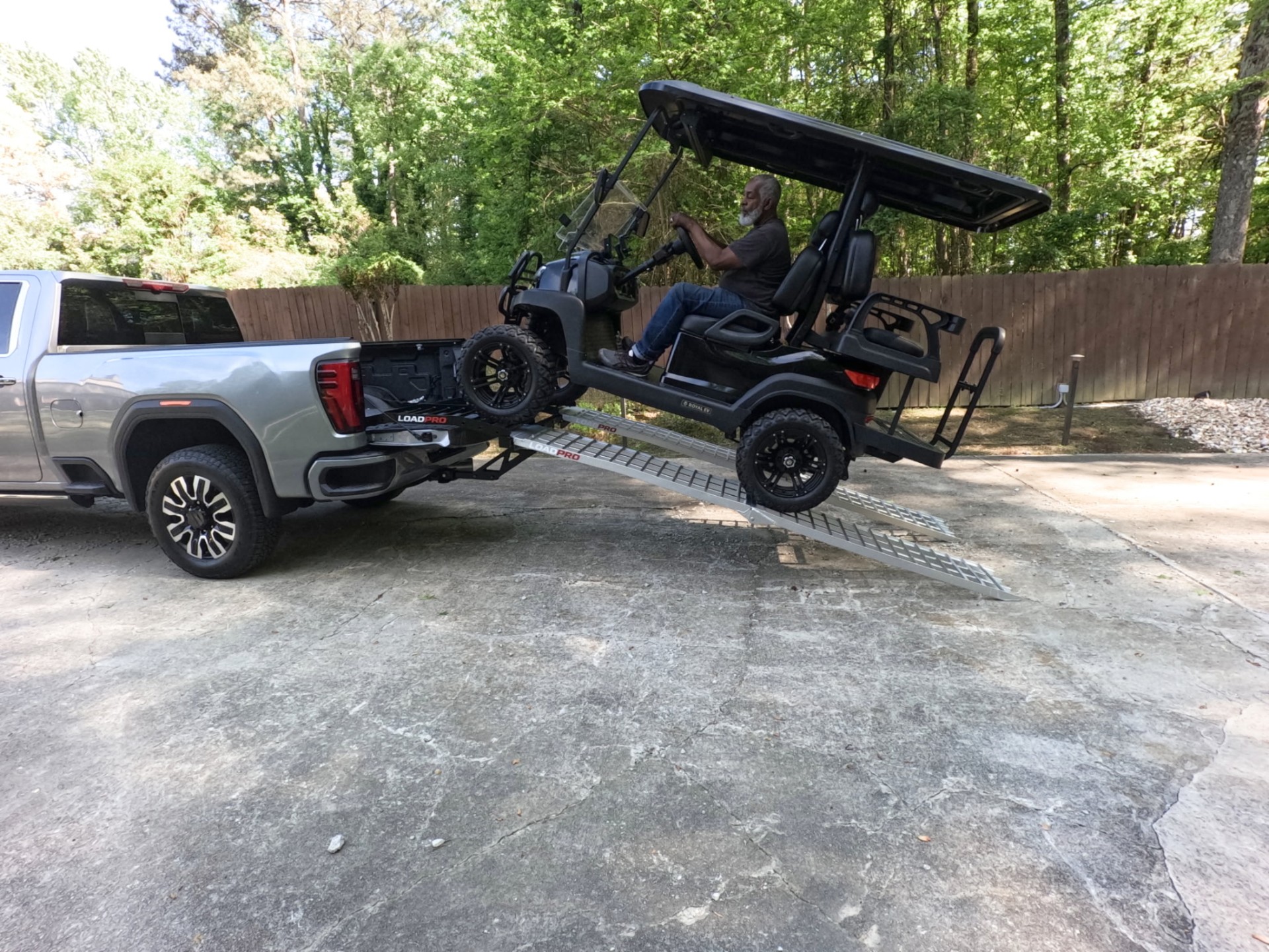 Golf cart being driven up Load Pro ramps into a pickup truck bed