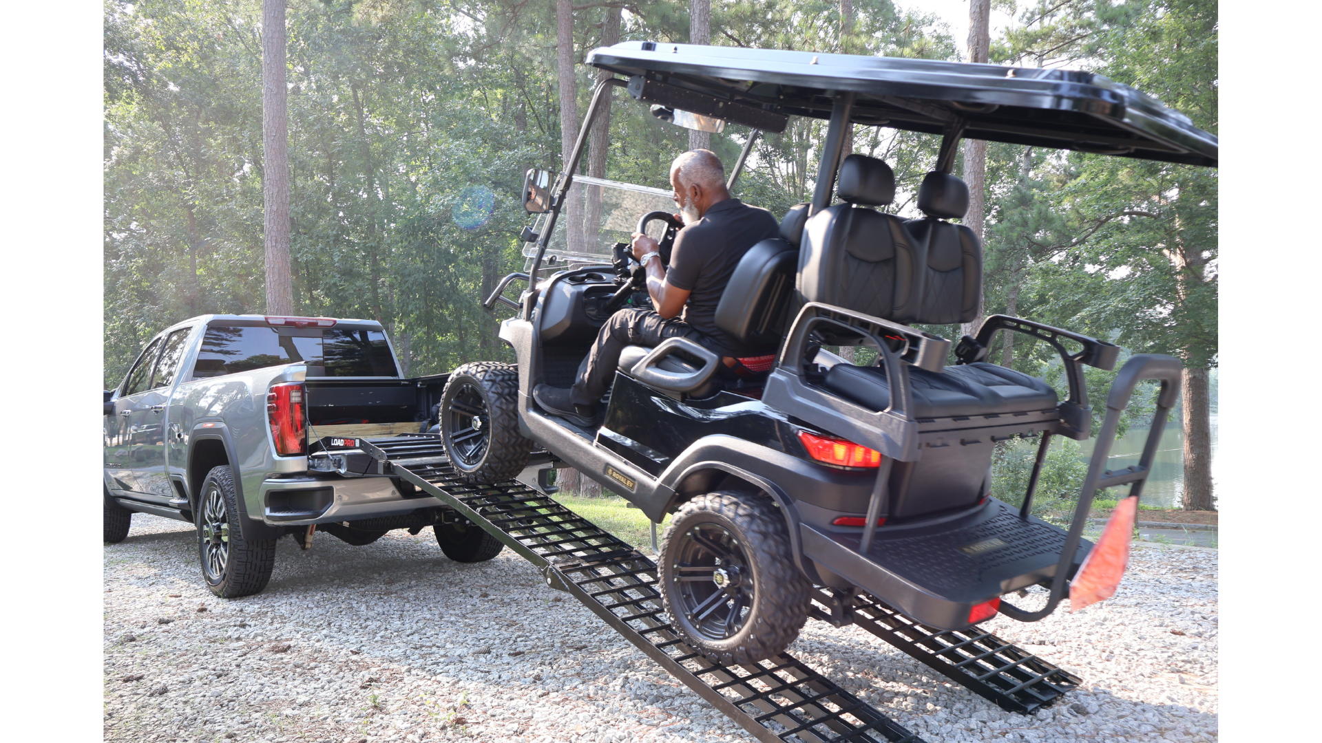Golf cart being driven up Load Pro ramps into a pickup truck bed